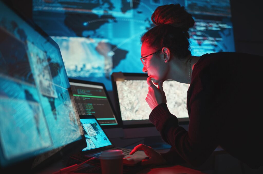 Analista de ciberseguridad monitorizando amenazas sobre un mapa de red global