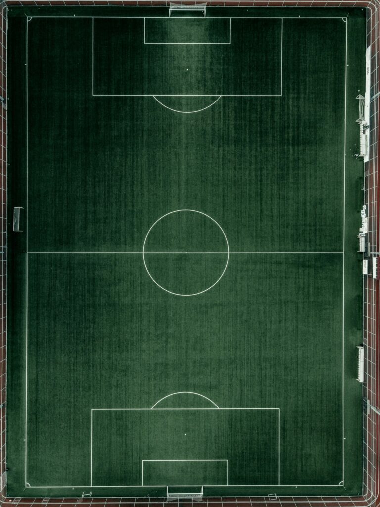 Pizarra táctica con el esquema de un campo de fútbol sobre fondo verde oscuro